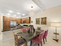 a kitchen and dining room area with marble table and pink chairs in front of the counter