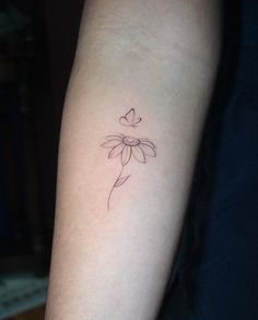 a small flower tattoo on the arm