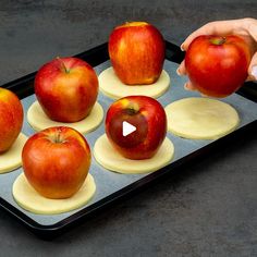 someone is placing apples on top of each other in a pan to bake them