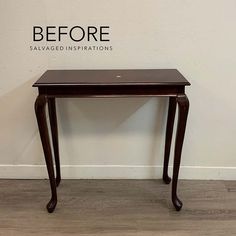 a small wooden table sitting on top of a hard wood floor next to a white wall