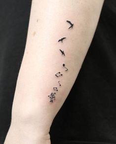 a woman's arm with music notes and birds on it