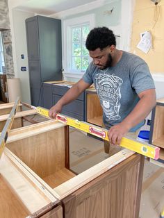 a man is measuring the width of his kitchen cabinets