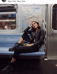 a woman sitting on a subway train seat with her hand under her head and looking off to the side