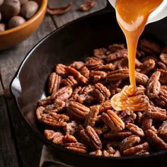 nuts being poured into a skillet on top of a table