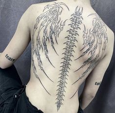 the back of a man's body with tattoos on his upper and lower back