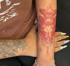 two people with tattoos on their arms and one has a butterfly tattoo on her arm