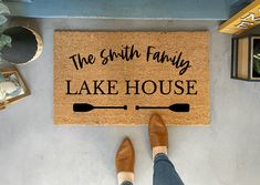 a door mat that says the smith family lake house with a person standing next to it