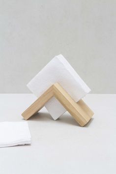 three folded napkins sitting on top of each other in front of a white wall