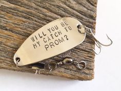 a fishing lure with the words will you be my catch to prom? on it