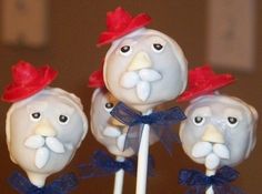 three cake pops with white frosting and red bows on them