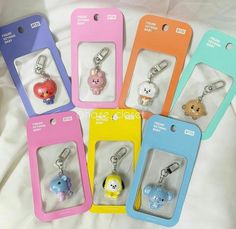 six keychains with various cartoon characters on them in different colors and shapes, all lined up against a white background