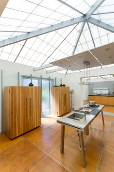 an open kitchen with wooden cabinets and white walls, along with a skylight overhead