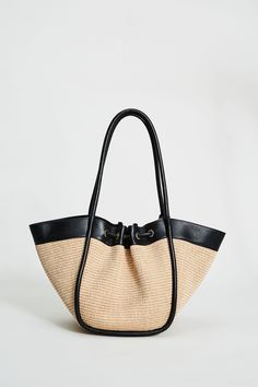 Step into Spring in style with our exclusive Raffia Tote Bag. Handcrafted in Italy, our chic, drawstring handbag is designed in the finest raffia fabric with contrasting Nappa Leather trim & gold handwear. With so many essentials to carry these days, this handbag puts the fashion in function with its knot Closure & ruched detailing. Elie Tahari Exclusive Raffia & Italian Leather Tote Bag with Gold Stud accents & a drawstring Knot Closure Measurements: 10" L, 20" Width, 12" Opening; Base 8"x6" Ma Luxury Straw Bucket Bag With Braided Handles, Luxury Summer Bag With Rolled Handles, Luxury Double Handle Beach Bag For Travel, Chic Straw Bag With Leather Handles, Luxury Straw Tote Bag With Rolled Handles, Luxury Straw Bucket Bag For Shopping, Elegant Straw Bag With Leather Handles For Shopping, Chic Black Straw Bag, Luxury Bucket Straw Bag For Shopping