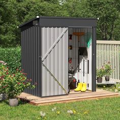 a metal shed sitting on top of a lush green field next to a wooden deck