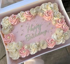 a pink and white birthday cake in a box