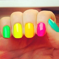 a person with bright colored nail polish on their nails