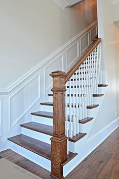 a white staircase with wooden handrails in a house