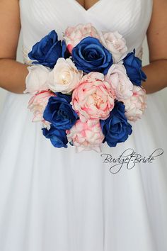 a woman in a white dress holding a bouquet of blue, pink and white flowers