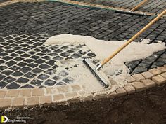 a manhole hole with a shovel laying on the ground next to it and some bricks