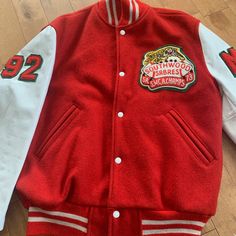 "This piece is a beautiful vintage leather high school letterman jacket from the 1970s for Southwood Secondary School Sabres in Cambridge, Ontario, Canada. This red and white bomber coat has chenille embroidered patches on either sleeve and one on the front with a Sabre on top of a football. -A few scuffs on the white leather Tag Size: 40 *refer to measurements for true fit* Pit to Pit: 24\" Length: 26.5\" Please also assess the photos and measurements carefully using your own personal judgement as we do not accept returns. Keep in mind that this is a piece of vintage clothing that may hold a residual scent from its past. While we wash all of the clothing we sell (except for certain items which are steam cleaned) we cannot guarantee that we have been able to remove all of the stubborn scen Retro College Outerwear With Button Closure, Retro Outerwear With Button Closure For College, Vintage Fall Varsity Jacket With Button Closure, Fall Vintage Varsity Jacket With Button Closure, Vintage Varsity Jacket With Button Closure For Winter, Vintage Winter Varsity Jacket With Button Closure, Vintage Varsity Jacket With Button Closure For Streetwear, Retro Winter Varsity Jacket, Vintage Red Varsity Jacket With Long Sleeves