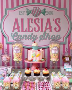 a candy shop display with pink and white striped walls, lots of candies on the table