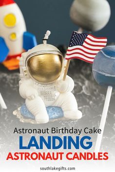 an astronaut birthday cake sitting on top of a table with marshmallows in front of it