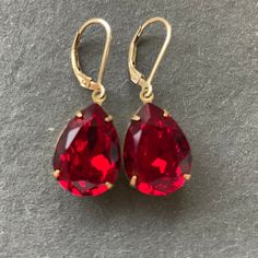 YUMMMMY color of the year 2023 VIVA MAGENTA ( the name is confusing, but it's really a red color) generously 18mm sized pear-shaped glass gems have been given a coating for EXTRA sparkle with These are set in gold plate over brass so they go perfectly with 14k gold filled leverback earwires.   The approx. Total length is 1.25" but these pack a lot of punch for their lightweight size! I AM OFFERING THESE IN SILVER  in a different listing . If you do not see them please contact me.  Your jewelry w Gold Red Earrings, Glam Earrings, Crystal Teardrop Earrings, Red Pendants, Red Jewelry, Ruby Earrings, Hollywood Glam, Earrings Red, Red Earrings