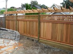 a wooden fence next to a brick wall