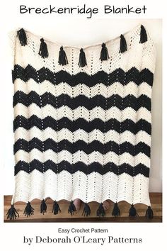 a black and white afghan with tassels on it