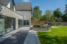 an outdoor patio with stone walls and green grass