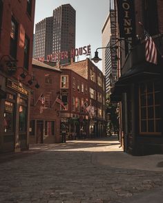 an empty city street with buildings and flags hanging from the side of it's sides