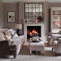 a living room filled with furniture and a fire place in the middle of the room