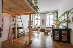 a living room filled with furniture and lots of plants on top of the shelves next to a fire place