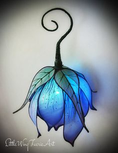 a blue flower hanging from the side of a wall