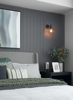 a bedroom with gray walls and white bedding