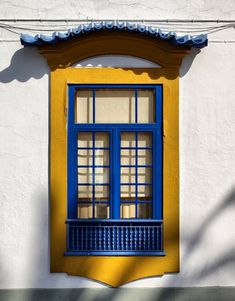 a yellow and blue window on the side of a building