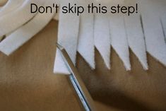 a pair of scissors sitting on top of some white fabric with the words don't skip this step