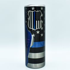 an american flag with the thin blue line on it is in front of a black and silver can