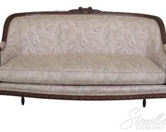 an old fashioned couch is upholstered with floral fabric and wood trimmings