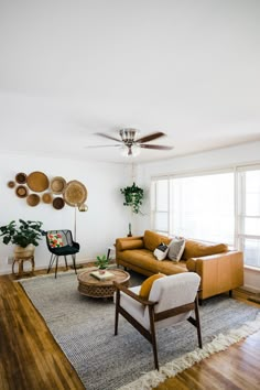 a living room filled with furniture and a ceiling fan