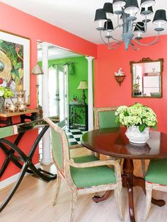 a dining room with green chairs and pink walls