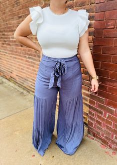 These denim wide leg tiered pants offer a lightweight and comfortable fit, making them perfect for all-day wear. The loose, flowy silhouette provides a flattering look, while the denim material adds a touch of classic style. Expand your wardrobe with these versatile pants. Flowy Tiered Skirt Bottoms For Brunch, Chic Rayon Wide-leg Pants, Casual Flowy Bottoms With Ruffles, Casual Flowy Ruffled Bottoms, Flowy Ruffled Casual Bottoms, Solid Rayon Bottoms For Spring, Flowy Rayon Bottoms With Ruffles, Flowy Ruffled Bottoms In Rayon, Flowy Ruffled Rayon Bottoms