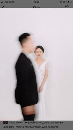 a man and woman standing next to each other in front of a white wall with text