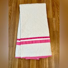 a white and pink towel on the floor