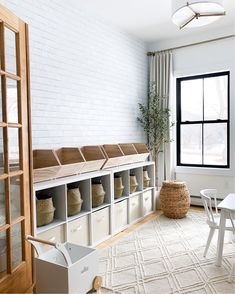 a room with white furniture and lots of storage boxes on the floor, along with windows