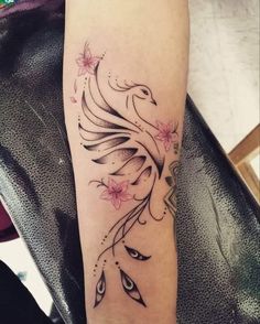 a woman's arm with a bird and flowers tattoo on the left side of her leg