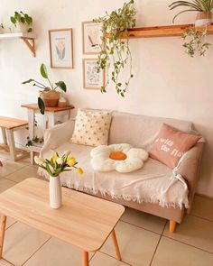 a living room filled with furniture and potted plants