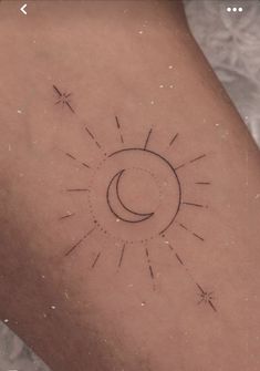 a small sun and moon tattoo on the back of a woman's arm,