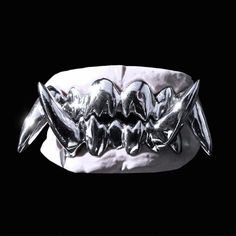 a close up of a silver bracelet on a black background