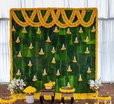 an arrangement of yellow flowers and decorations on a green backdrop for a wedding or reception